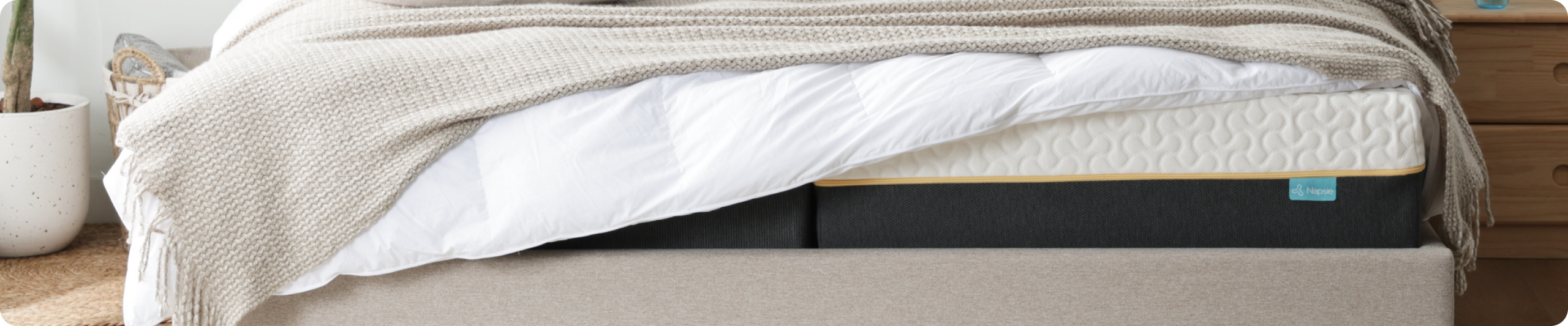 Moderne Matratze mit strukturierter Oberfläche und bequemer Bettwäsche im Schlafzimmer